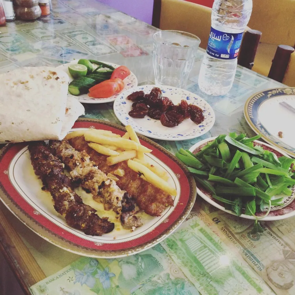 Currency notes under the glass tabletop alongside a kebab platter