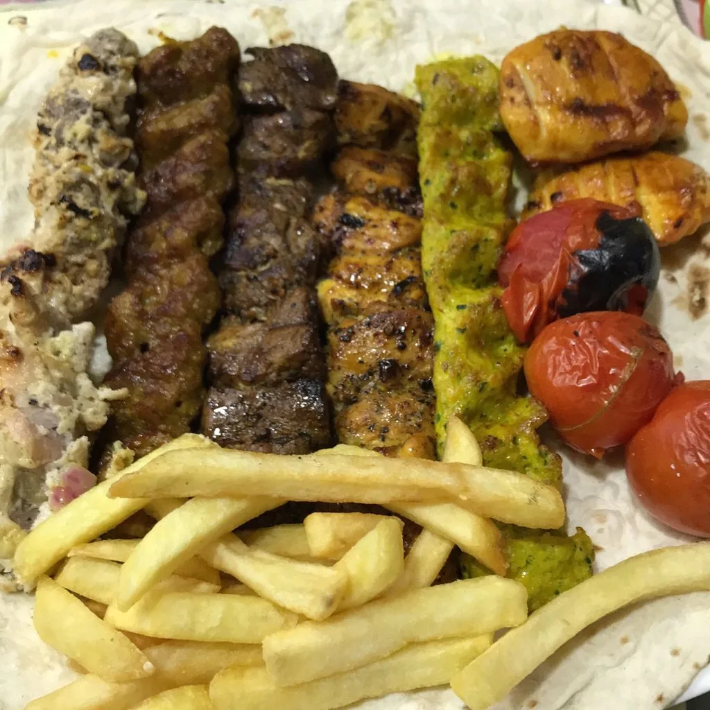 A mixed grill of joojeh kebab, koubideh, barg and grilled tomatoes