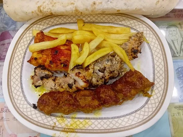 A platter of joojeh, koubideh and barg over naan
