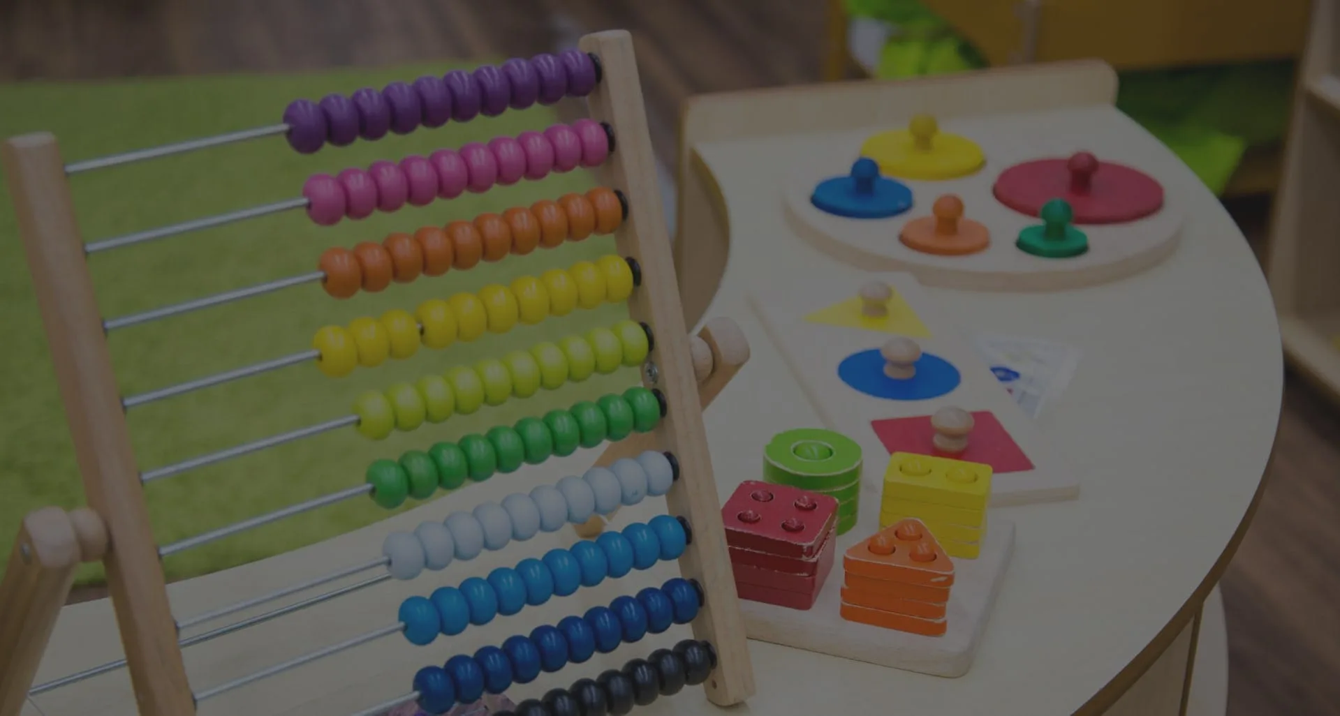A wooden Montessori counting frame beside colour, shape and pin-sorting materials.