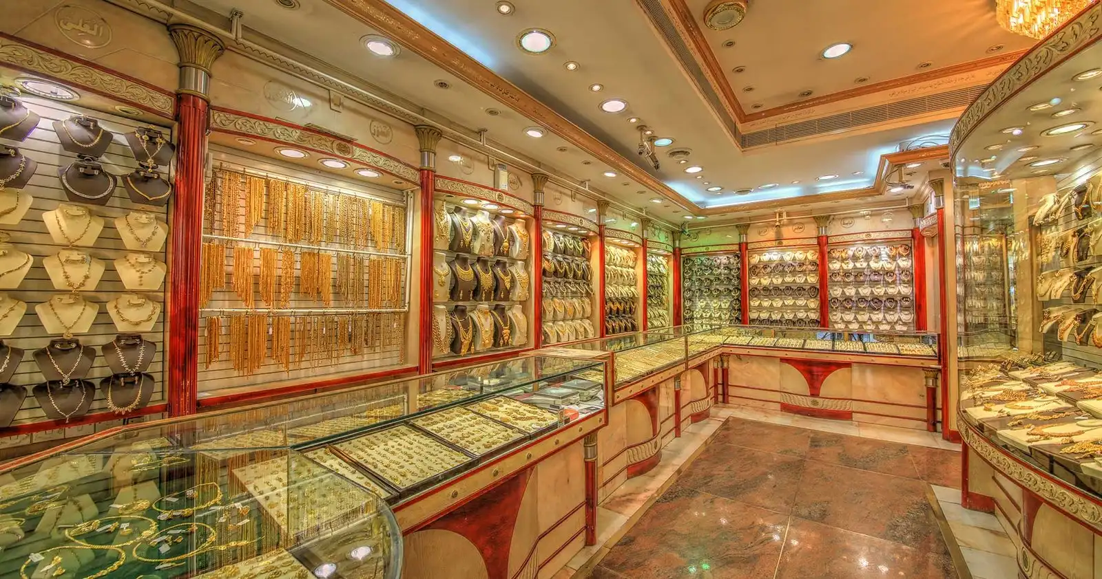 Al Mignas Jewellers showroom in the Deira Gold Souk, walls of gold necklaces under chandeliers