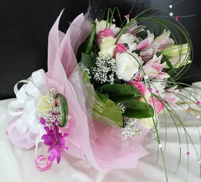 A soft bouquet of pink and ivory roses framed with gypsophila