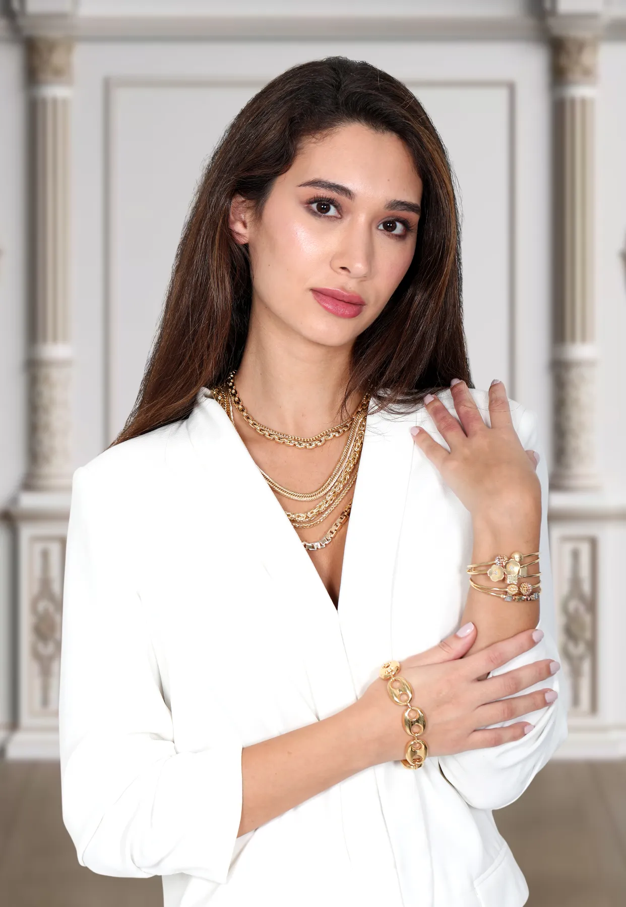 Model wearing layered Bafleh gold chains and bracelets