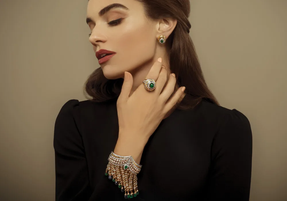 A Devji Aurum model wearing an emerald-and-diamond ring, earrings and a beaded statement bracelet