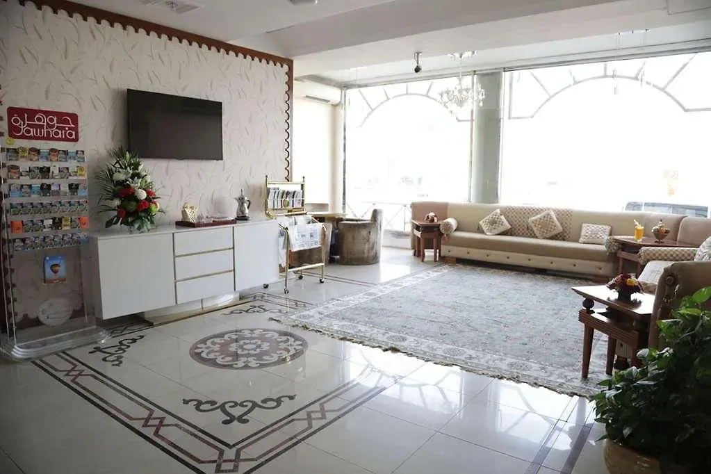 Bright lobby lounge with seating, chandelier and marble floor