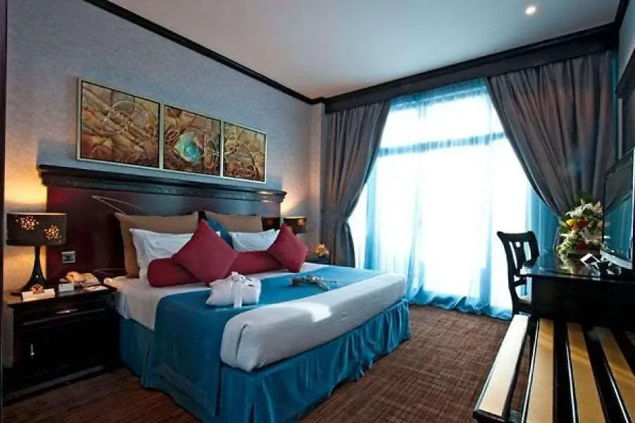 Deluxe room with a dark headboard, accent pillows and framed art