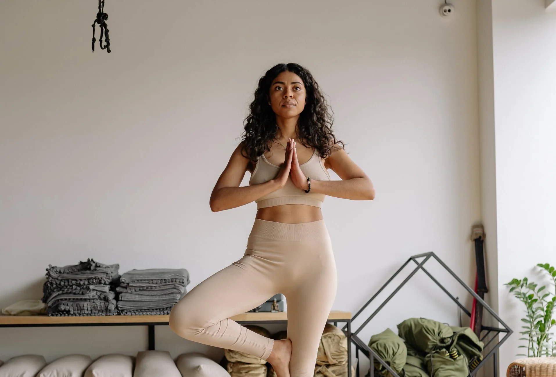 Woman in a balanced tree pose in a calm, light-filled studio