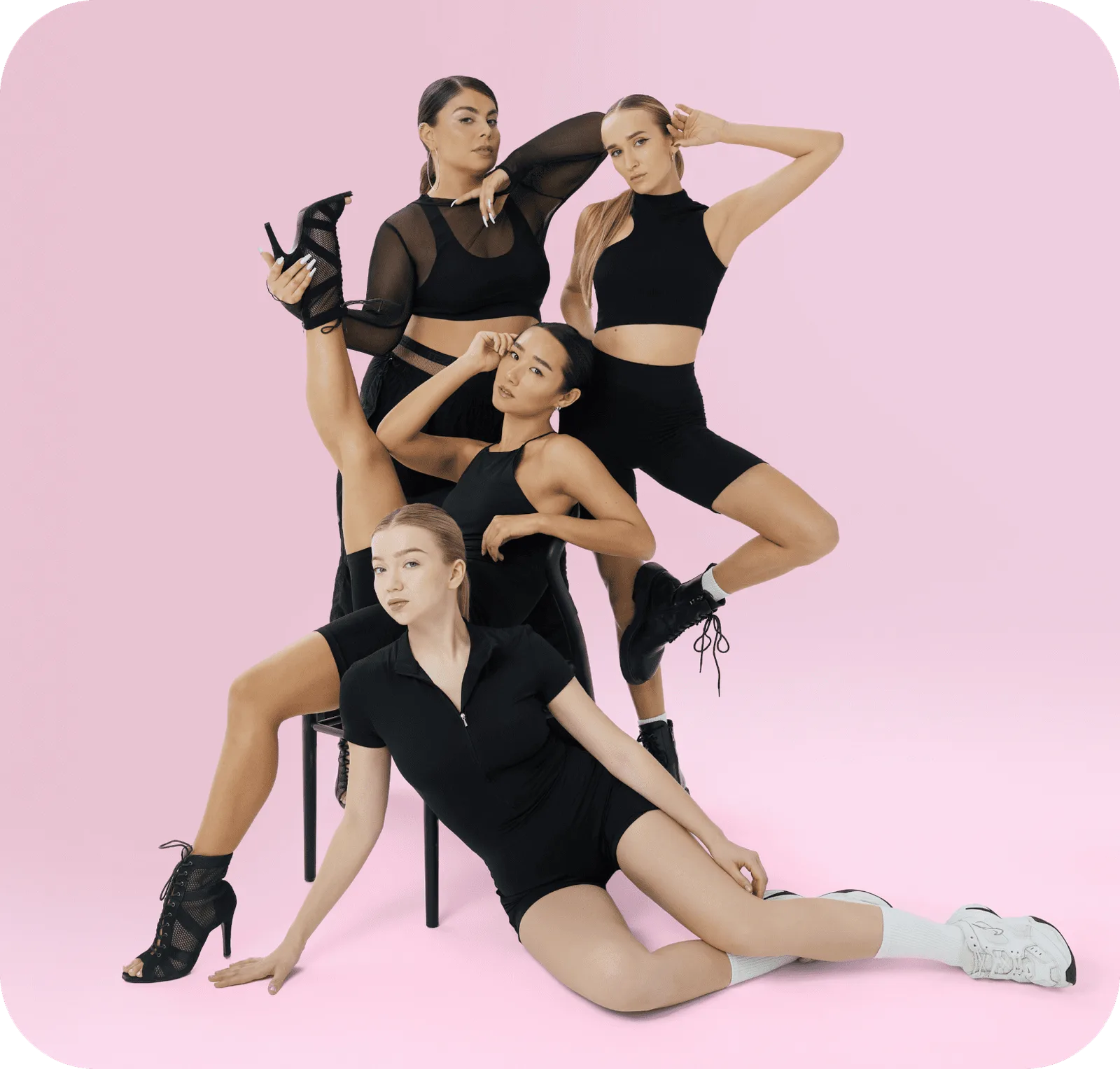 Four Moova Space dancers posing together on a pink studio backdrop