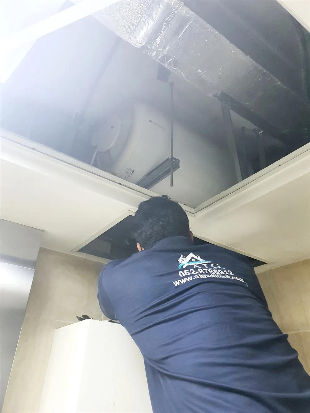 AJG technician working on ceiling ductwork