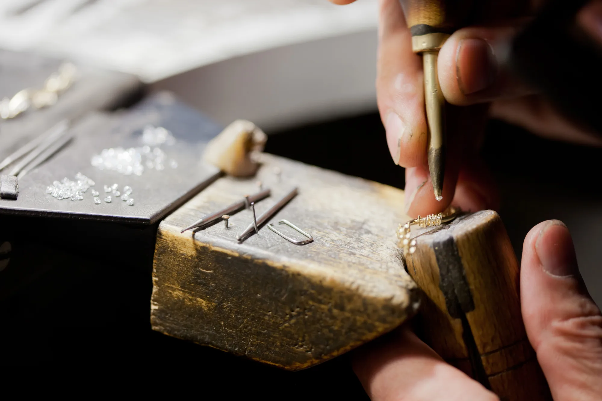 A KYRA goldsmith setting stones by hand at the bench