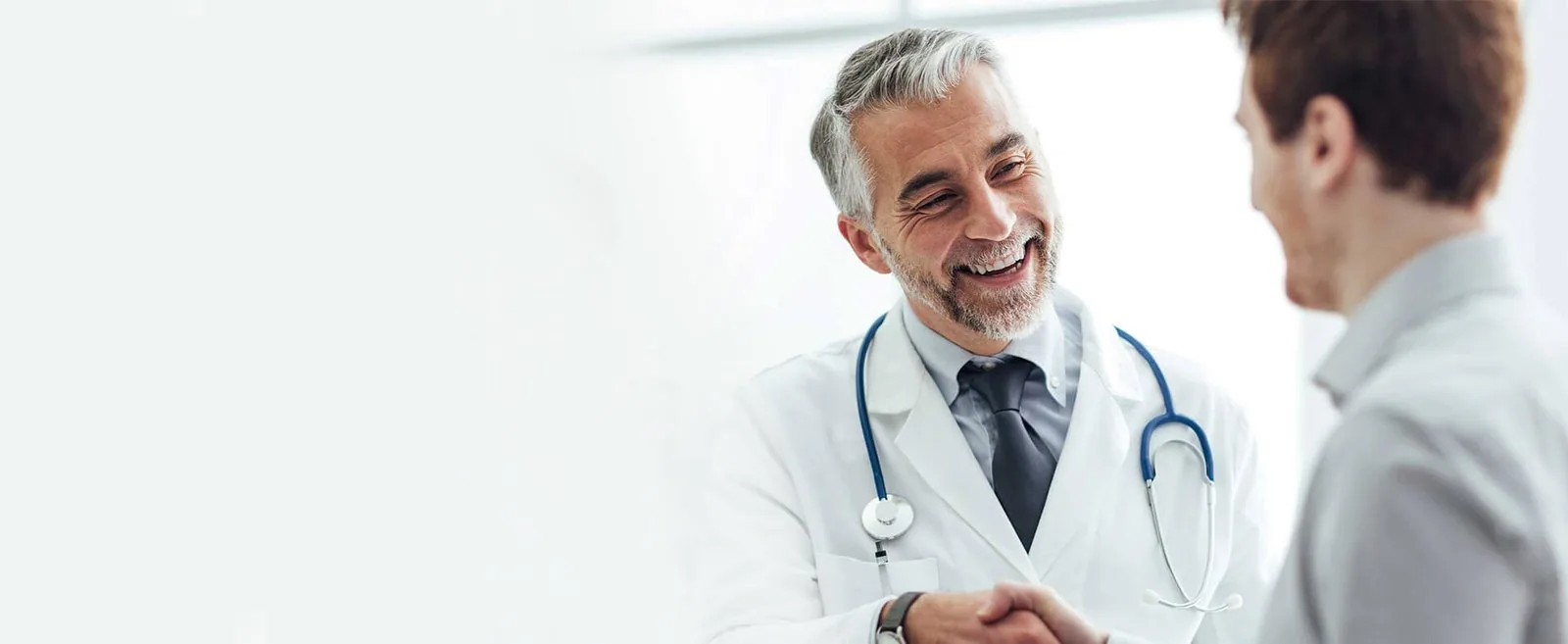 A doctor warmly greeting a patient at the clinic