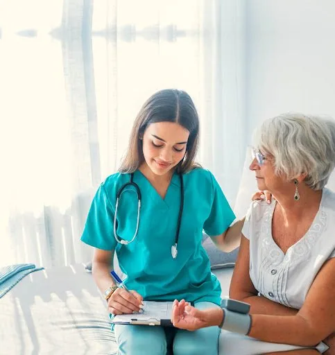 A nurse caring for an elderly patient at home