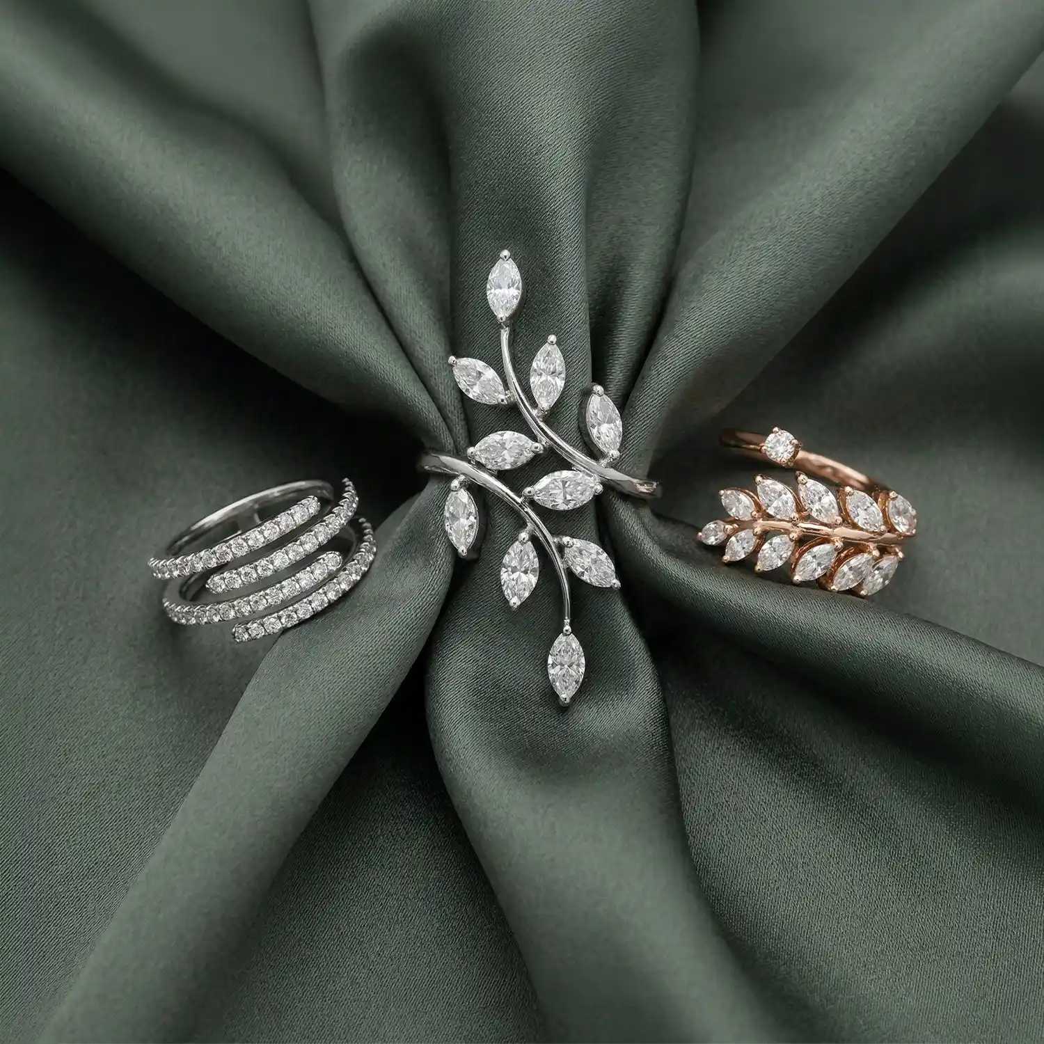 Marquise diamond vine ring and pavé spiral rings on green silk