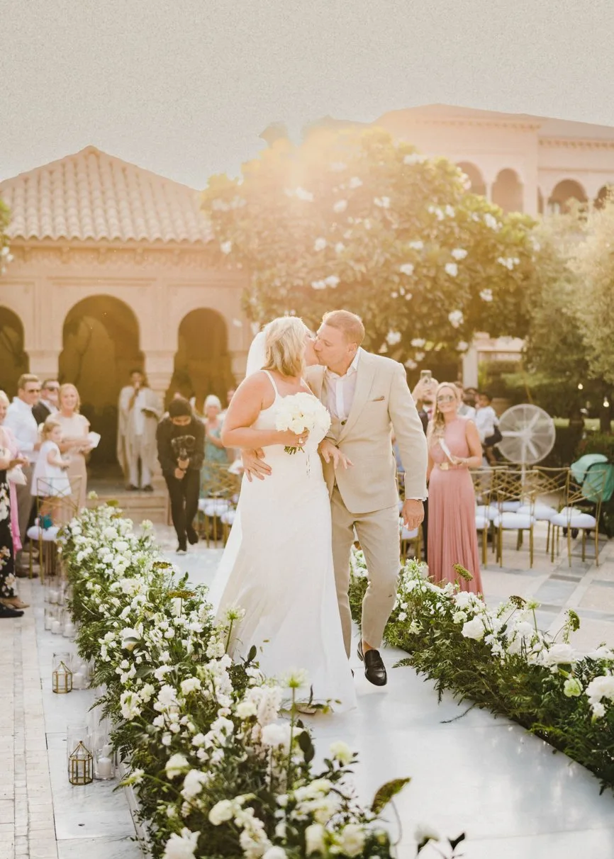 A couple share a kiss in golden evening light at a courtyard wedding photographed by Imprint