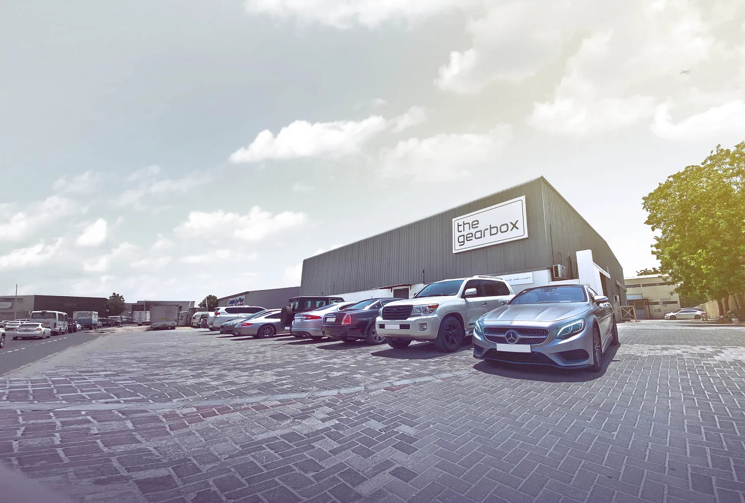 The gearbox warehouse exterior with branded sign and luxury fleet