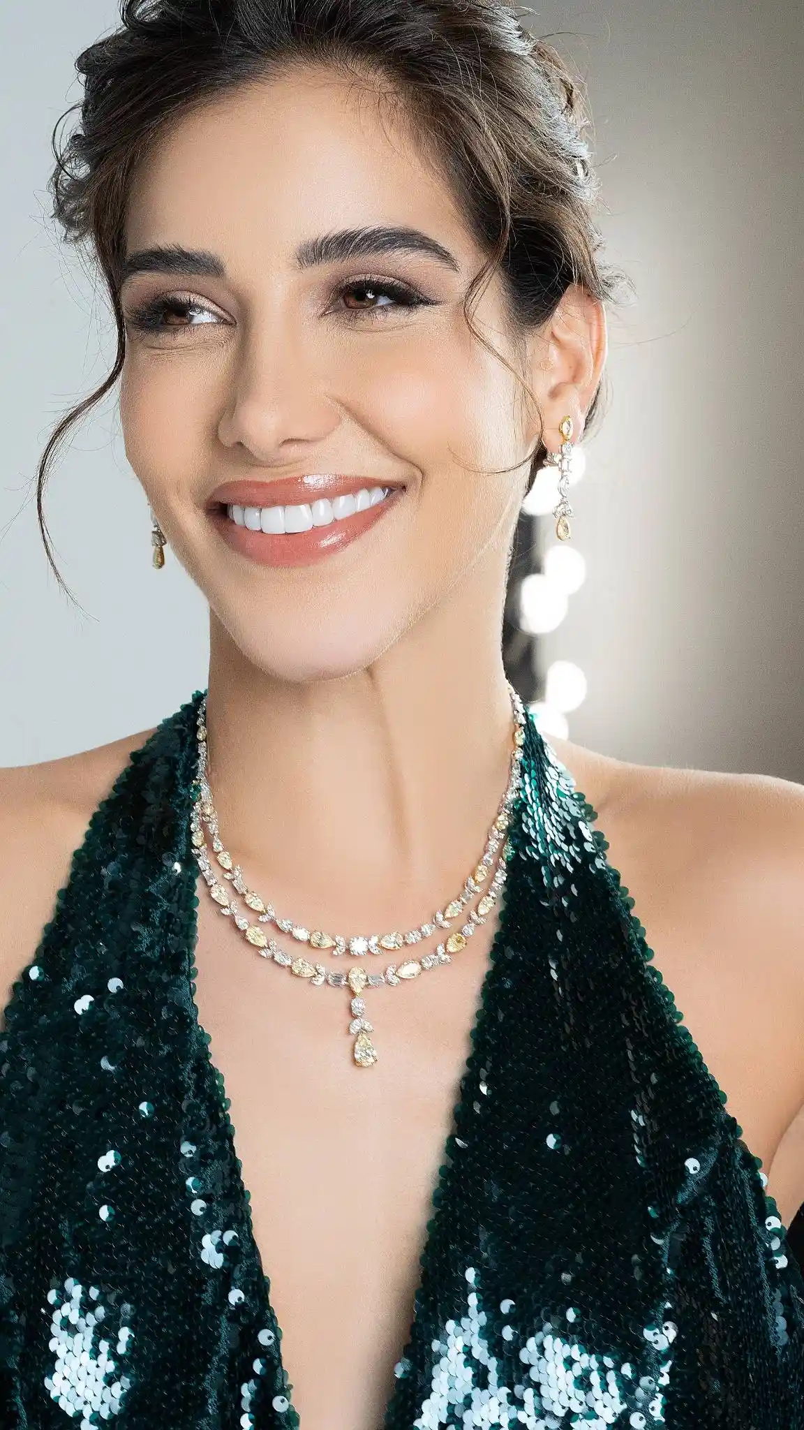 Model wearing a layered Al Anwaar yellow and white diamond necklace