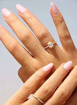 An emerald-cut diamond engagement ring worn on the hand
