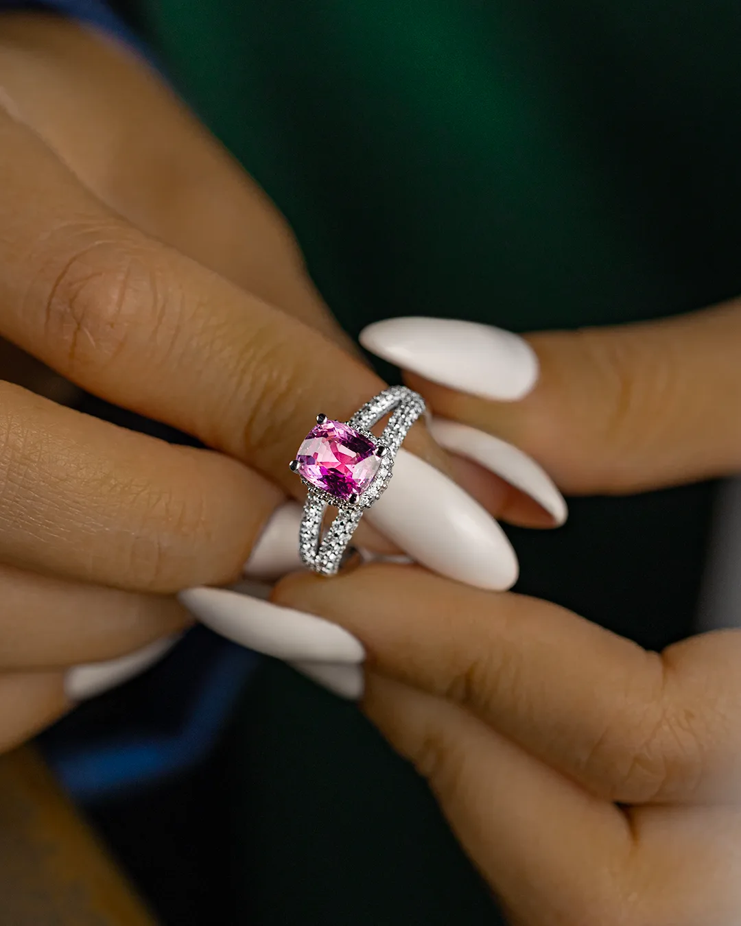 Pink-stone diamond ring worn on a hand
