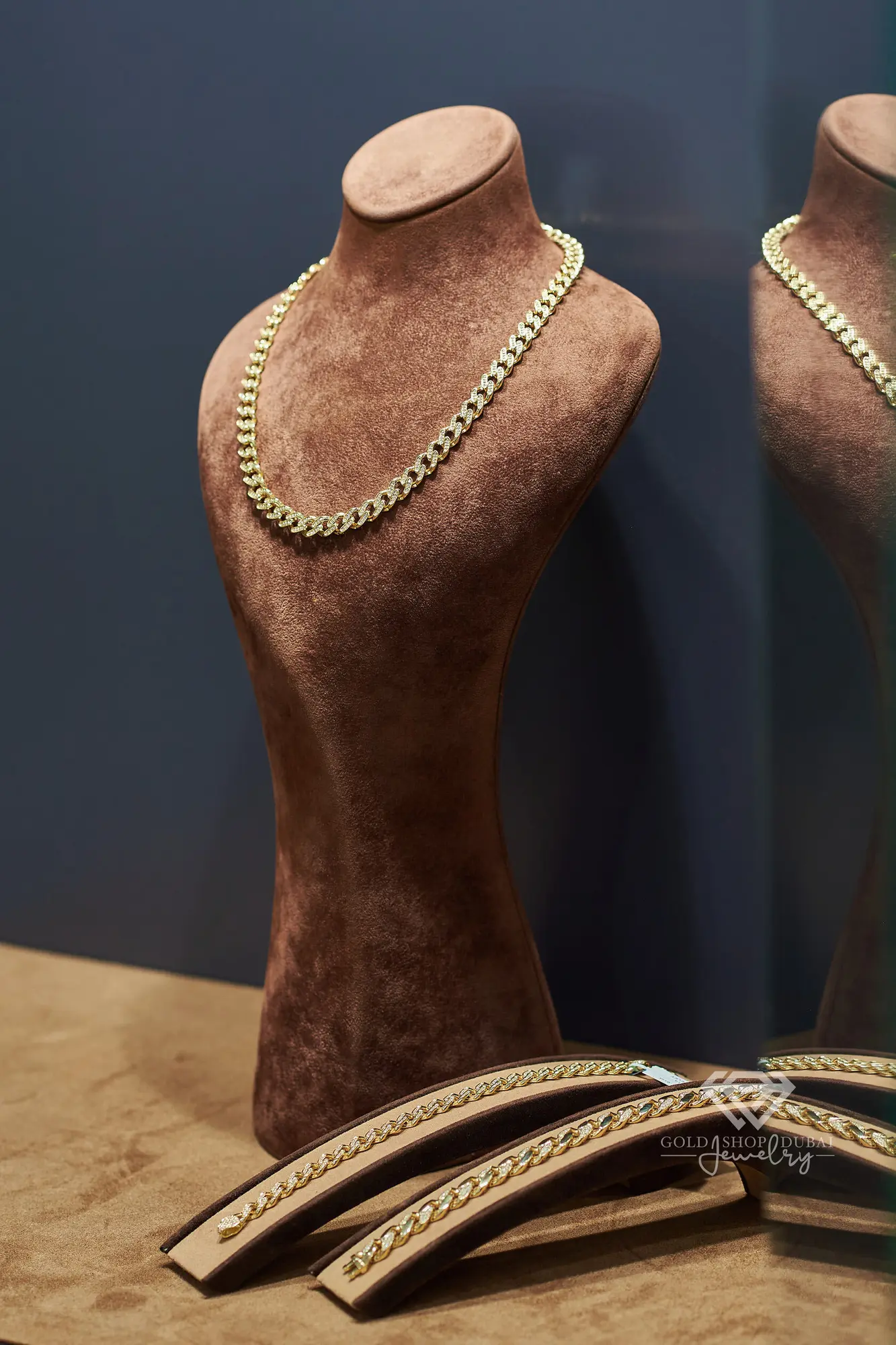 Diamond-set gold Cuban chain on a display bust