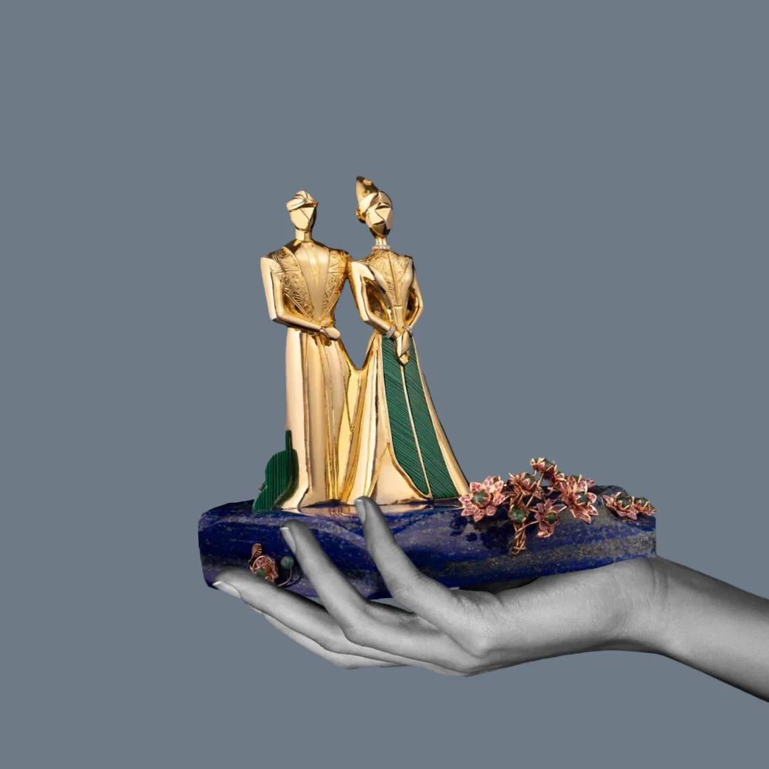 A bespoke Studio ALOI gold sculpture, ‘Eternal Union’, presented on a lapis-lazuli base held in the hand.