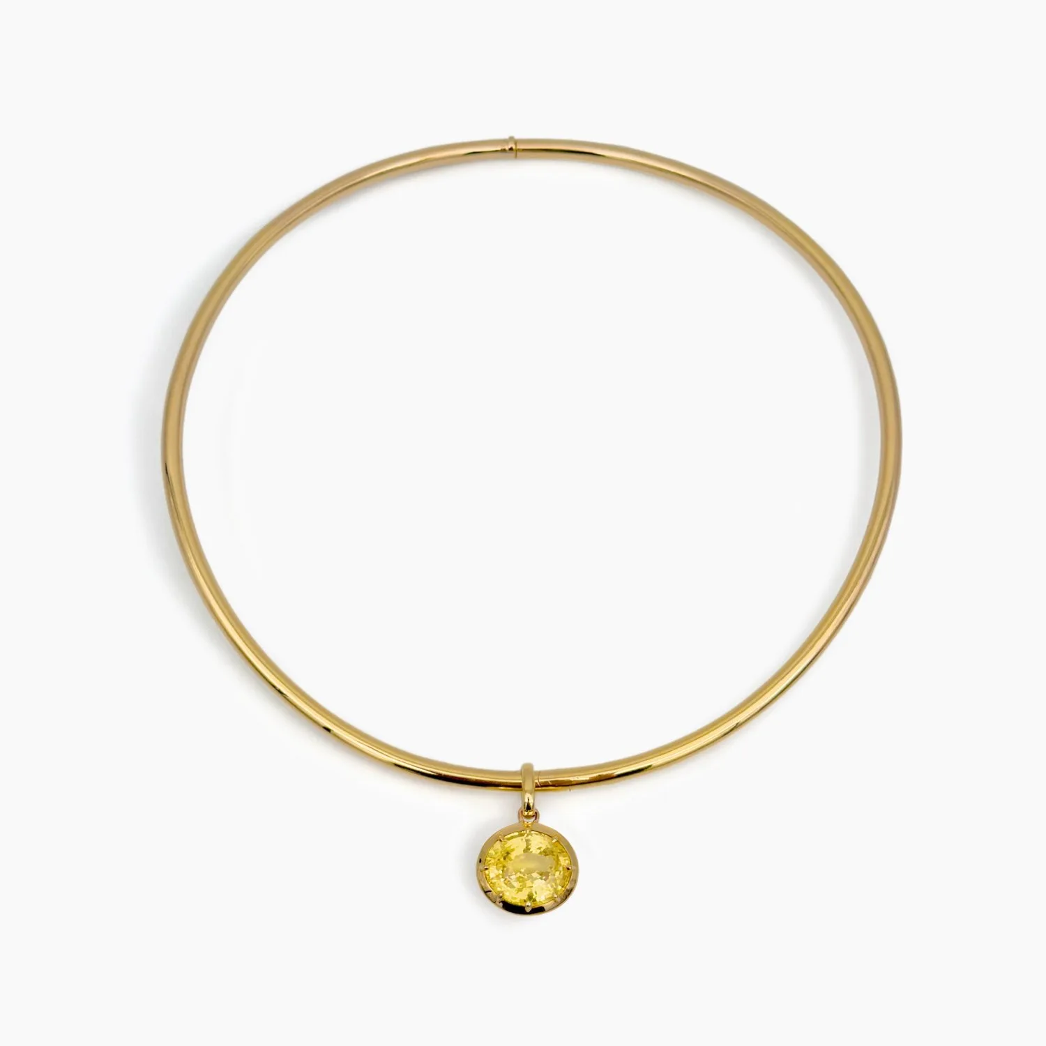 A gold necklace with a yellow gemstone pendant.