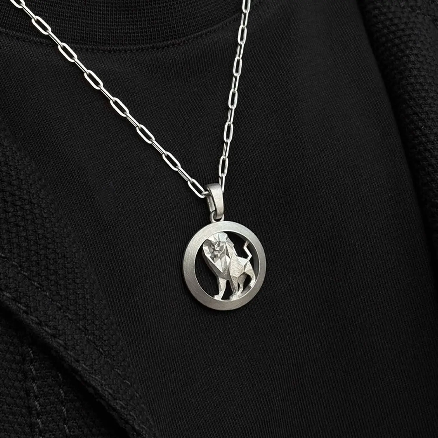 The finished faceted lion pendant worn on a chain.