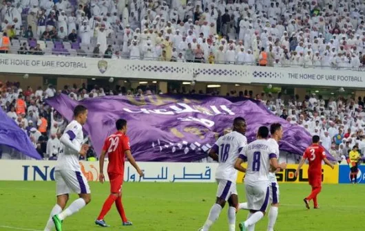 Printed fabric flag carried across a stadium pitch at a sports event