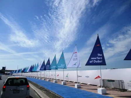Row of printed sail flags lining a Dubai canal walkway