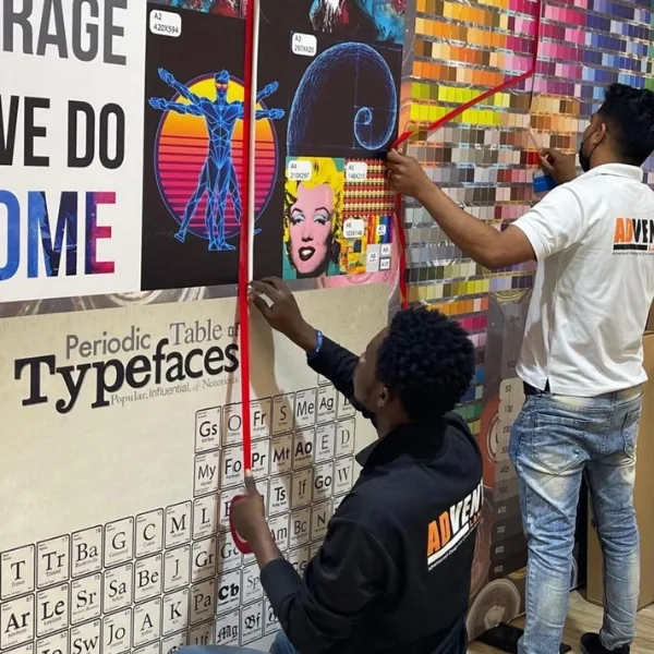 Advent Land team measuring and installing a large-format printed wall display