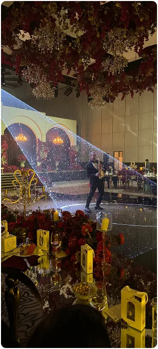 An elegant white wedding aisle under a floral chandelier, produced by Mramez Events