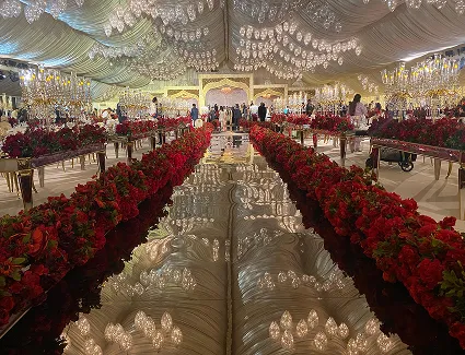 A Mramez Events wedding in Dubai — mirror-finish aisle lined with red roses under crystal chandeliers