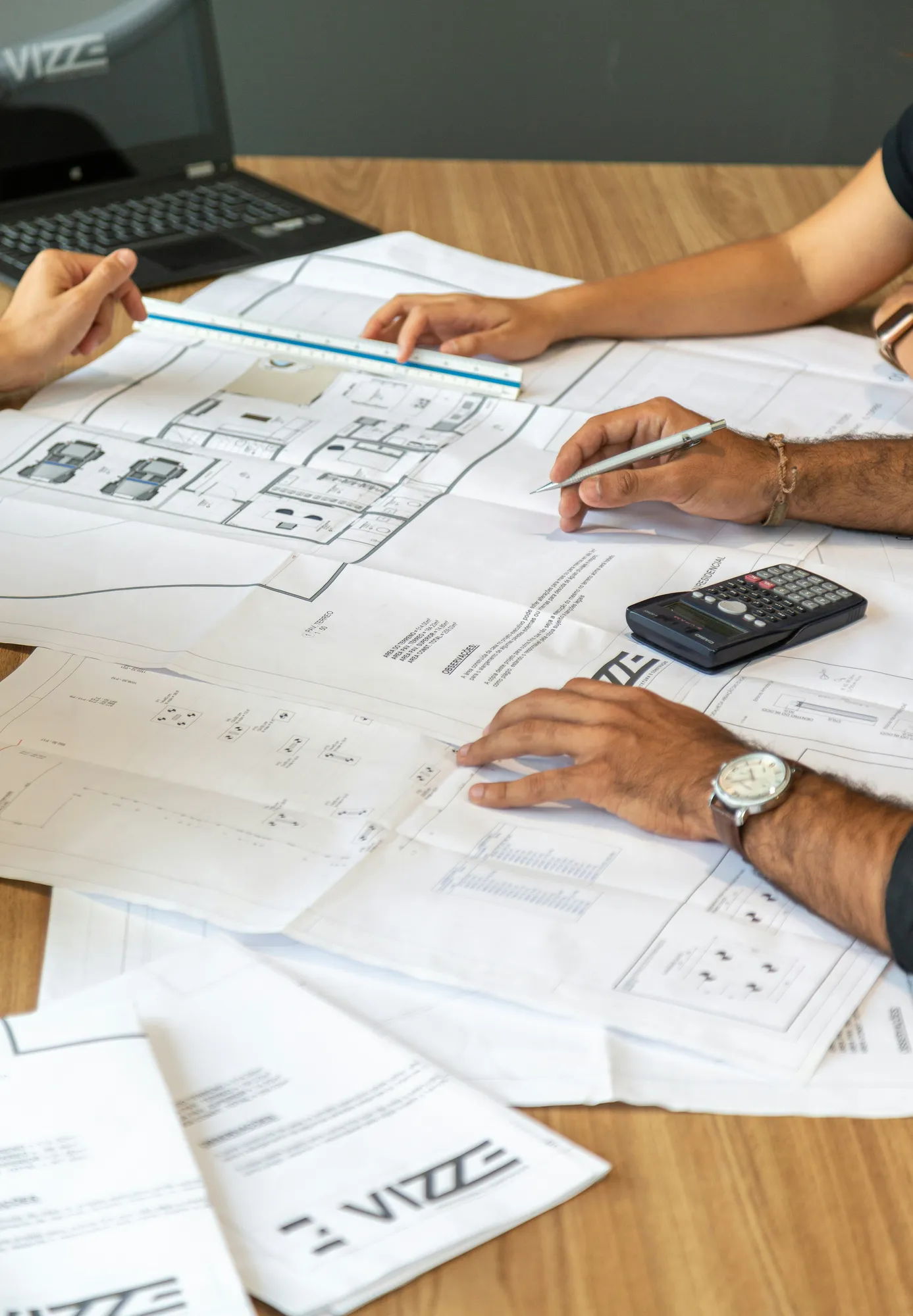 Engineers reviewing technical drawings over a desk in the studio