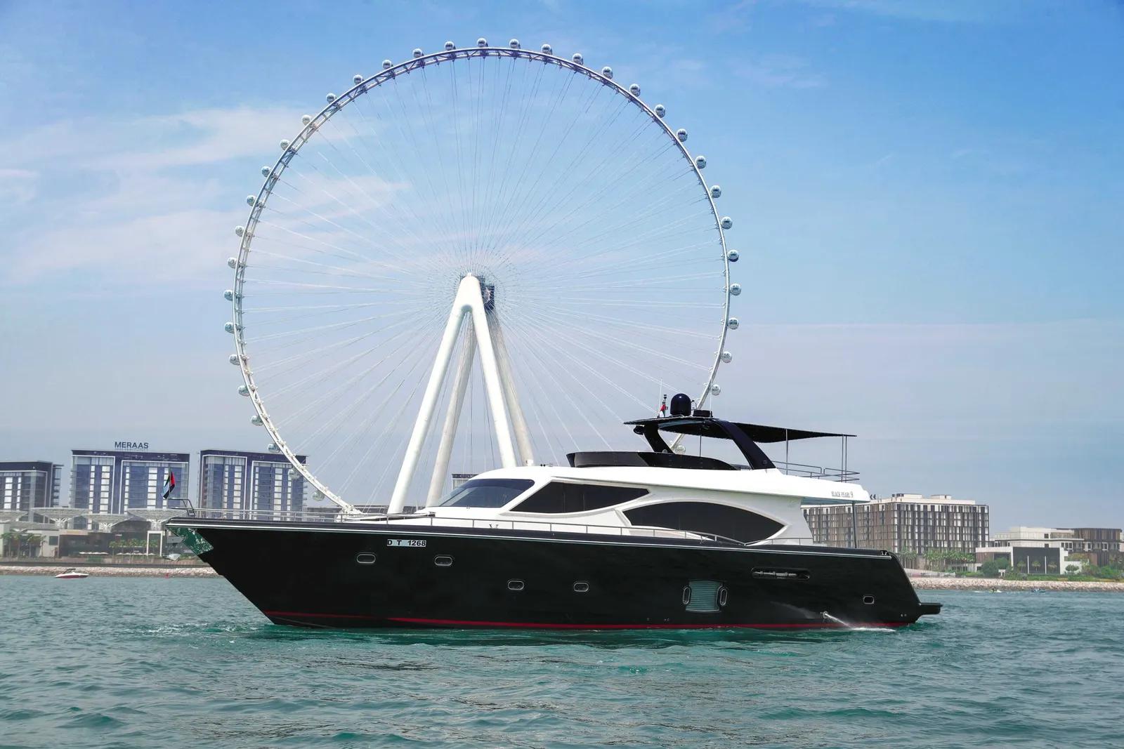 Sunseeker-style yacht on the water at dusk near the Dubai skyline
