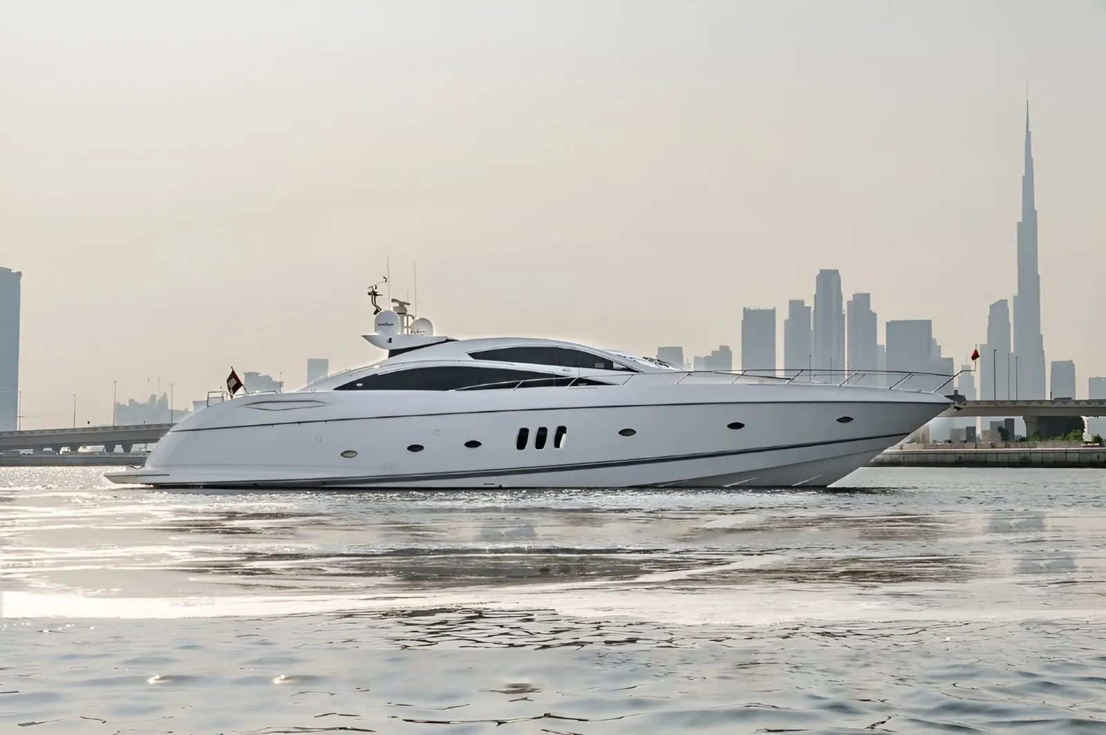 Yacht cruising past the Dubai skyline at golden hour