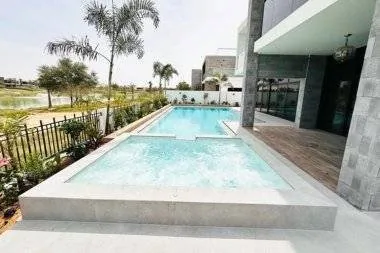 Overflow swimming pool with feature wall lit at dusk