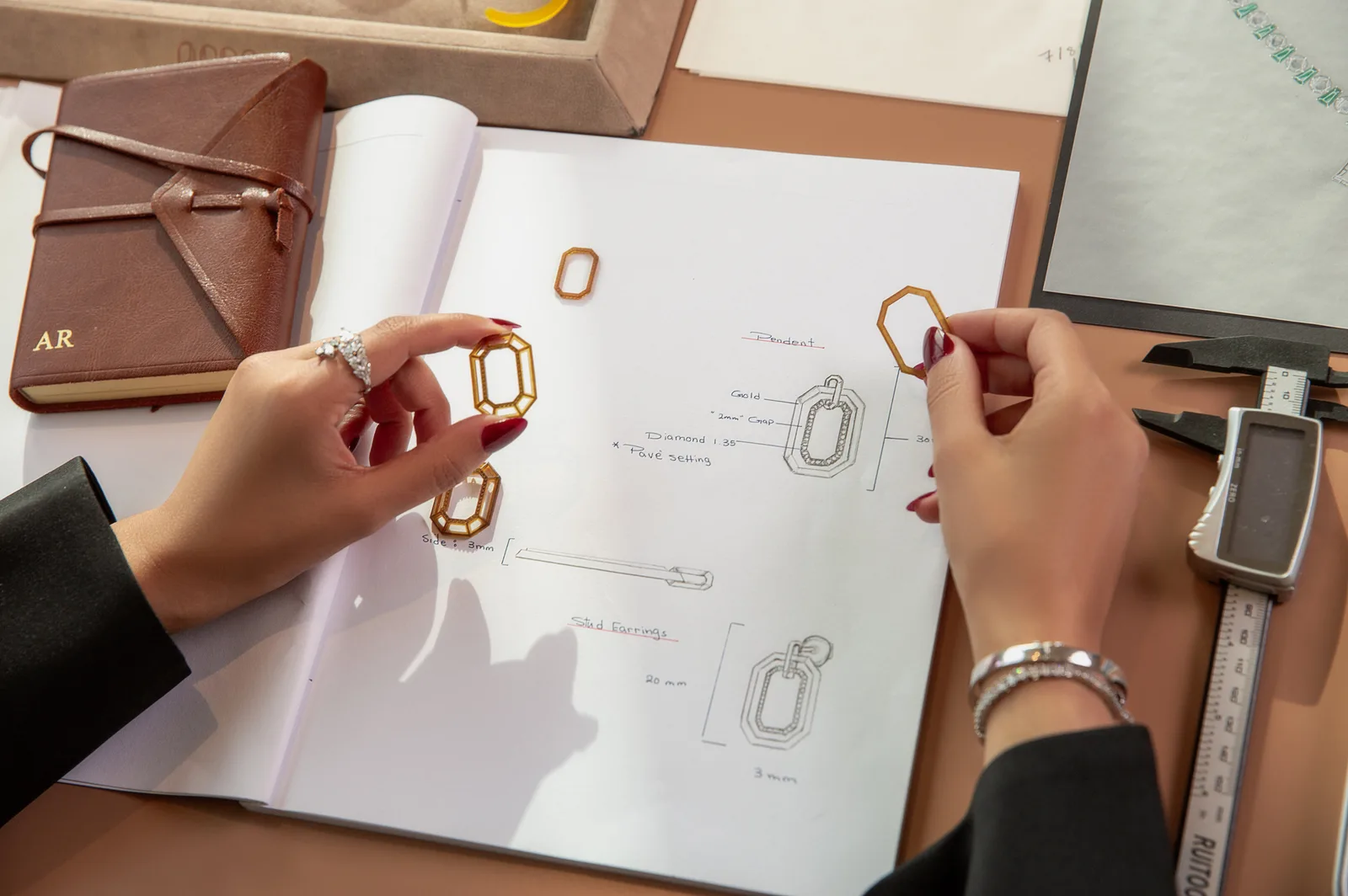 Designer Aisha Rashid at her workbench, sketching the Octagon pendant