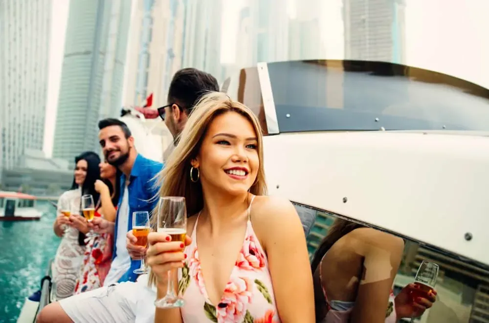 Guests with drinks aboard a yacht in Dubai Marina