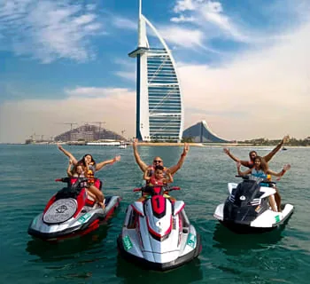 Friends jumping off a boat into clear Dubai water