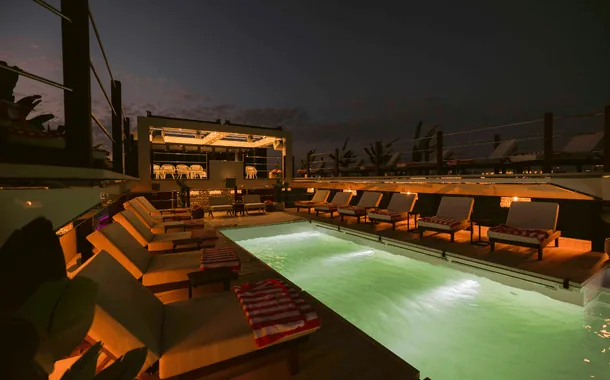 Floating beach club concept with poolside loungers at dusk