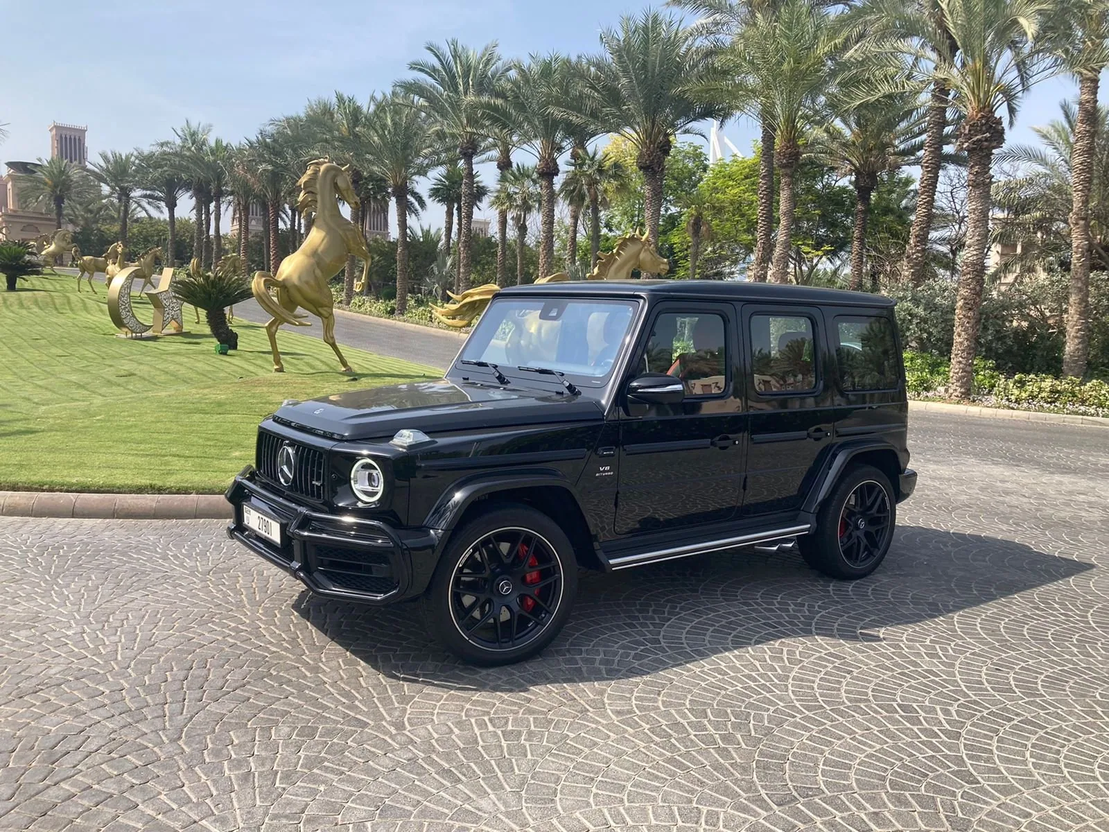 A black luxury SUV from the Rentega fleet parked at a landmark Dubai resort