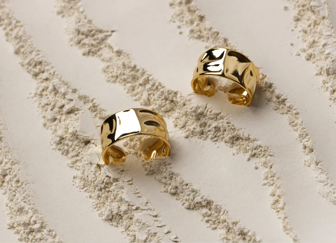 Arakkal gold rings on a sand-textured surface