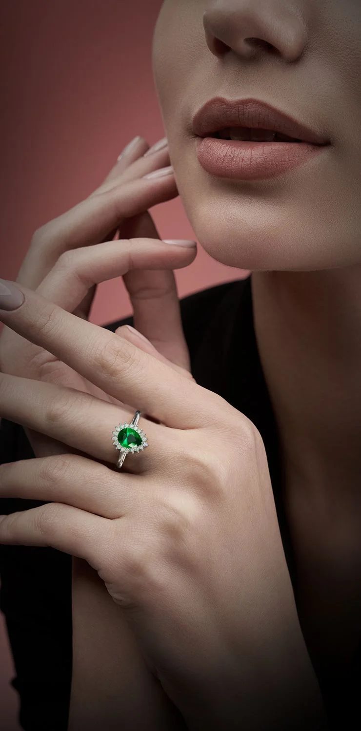 Emerald and diamond halo ring on dark stone