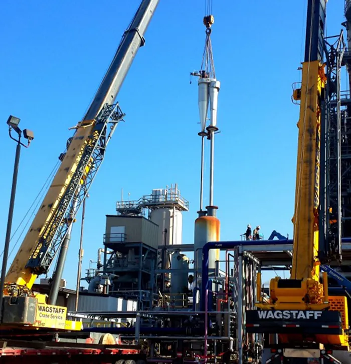 Heavy industrial plant construction — cranes lifting process vessels on an oil & gas site