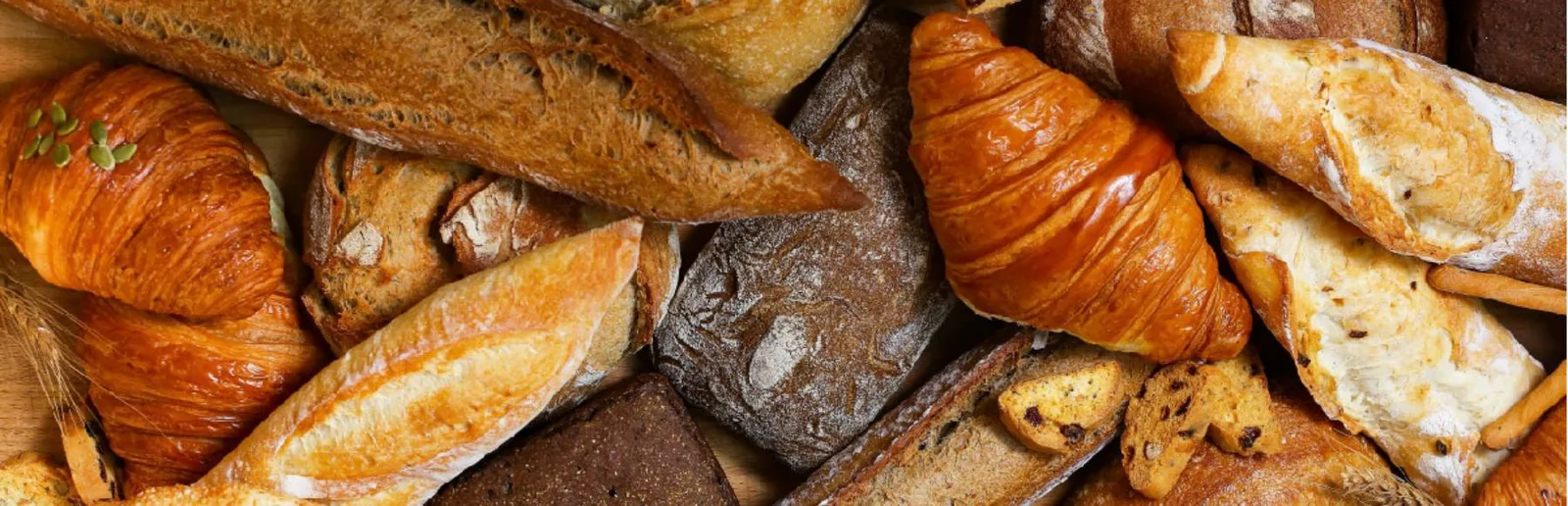 An overhead spread of freshly baked croissants, baguettes and artisan loaves at Bakerist
