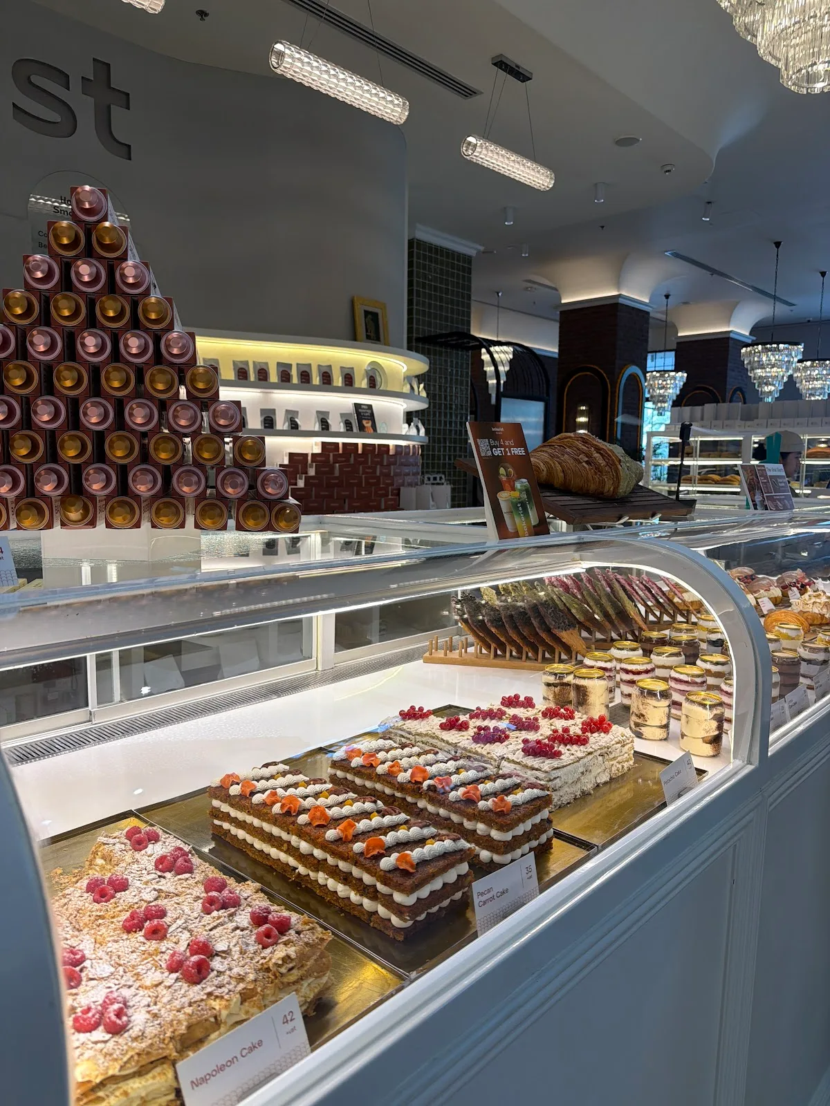 Glass case of Napoleon cake, carrot cake and patisserie
