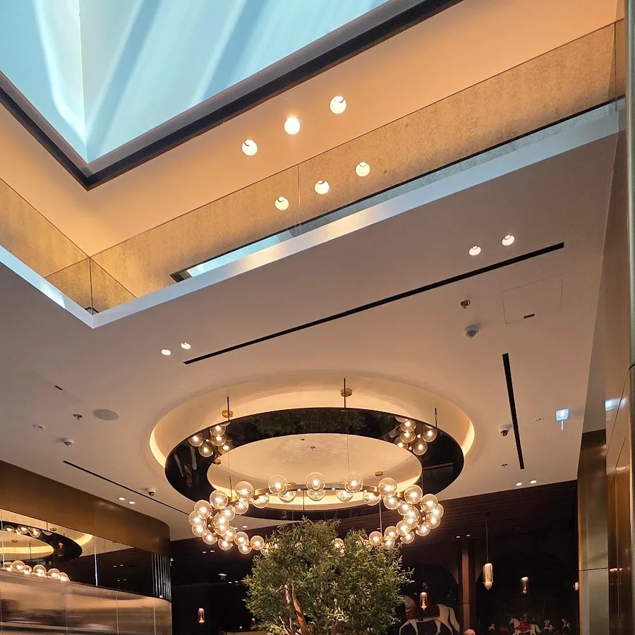 Atrium with a circular chandelier and olive tree at ZouZou