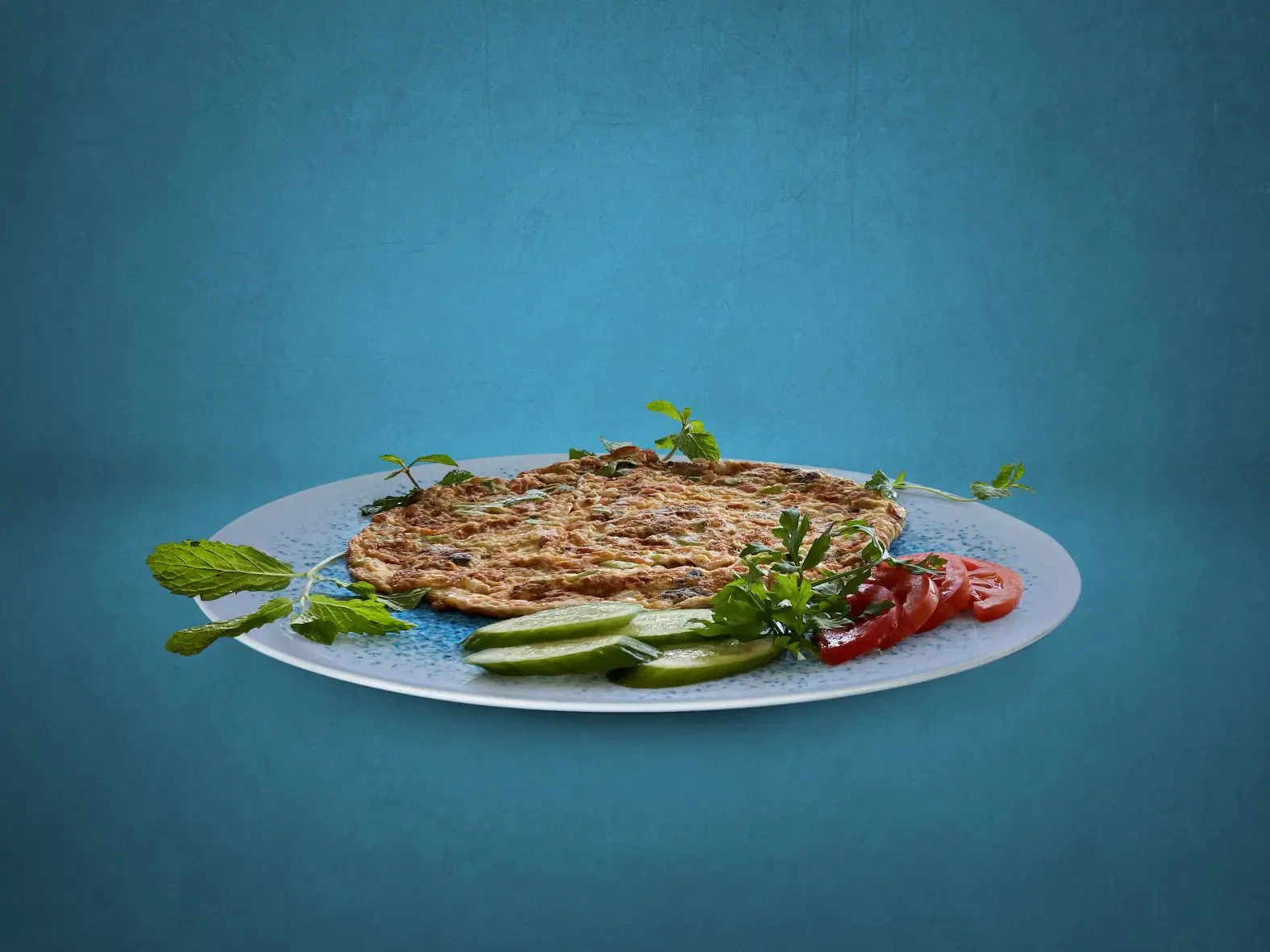 Herb omelette / eggah breakfast plate with tomato and cucumber