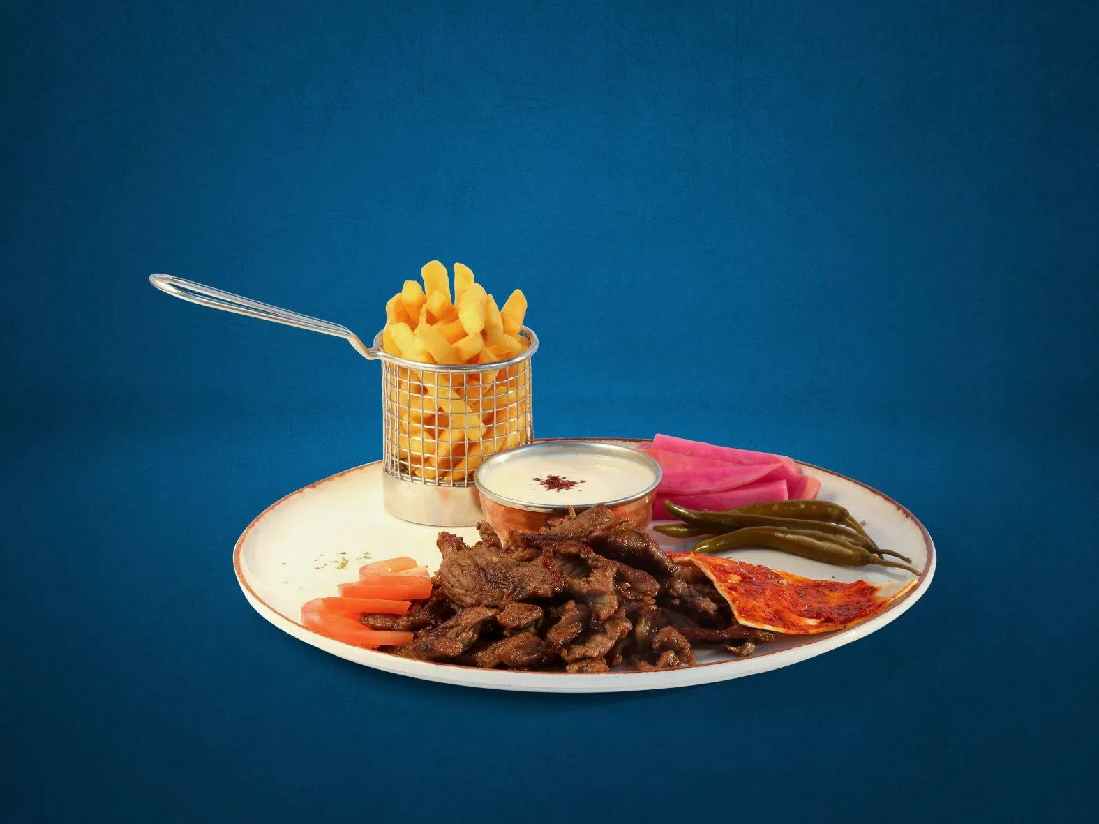 Shawarma meat plate with fries, pickles and garlic dip