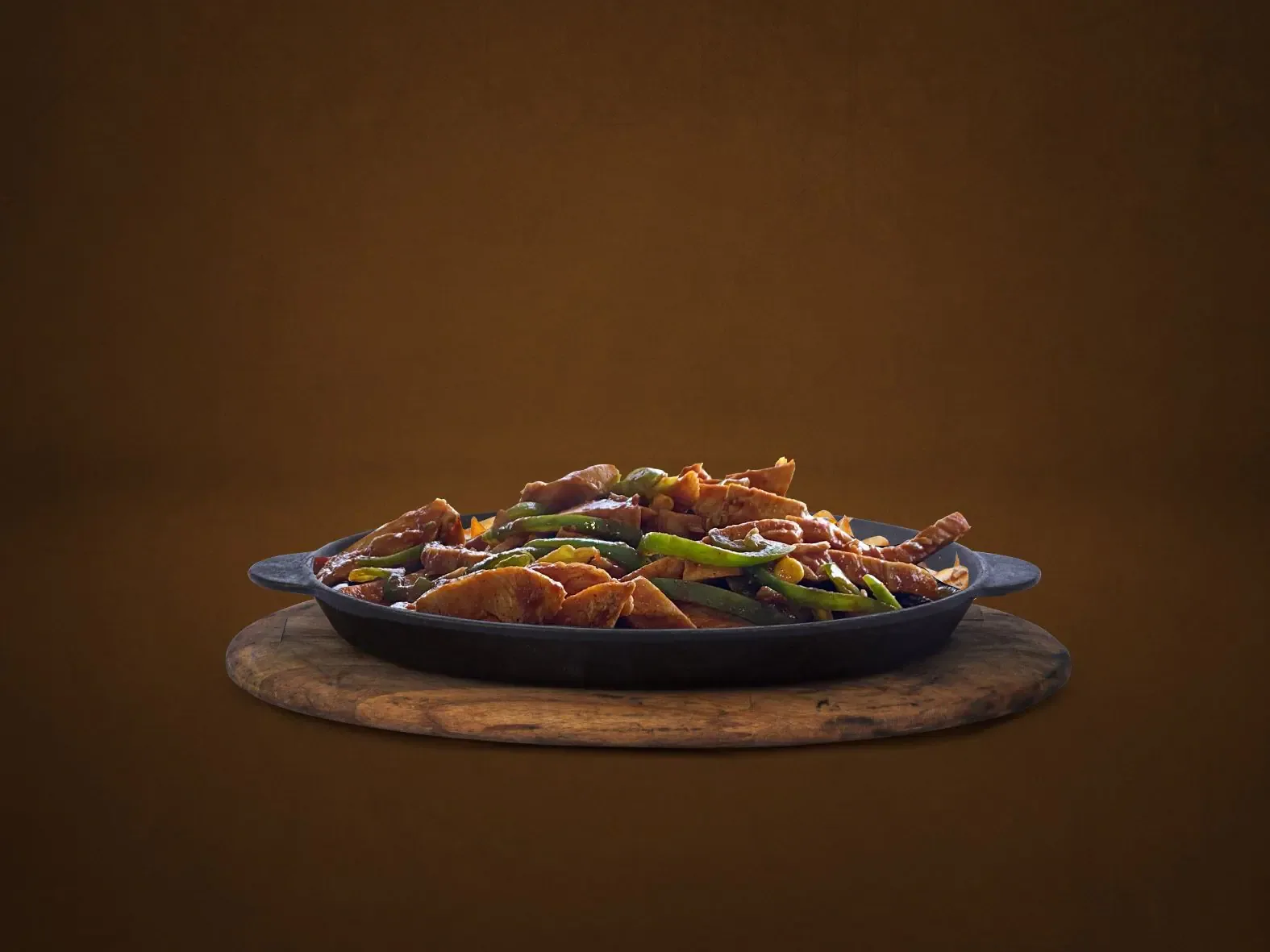 Sizzling skillet of grilled meat and peppers