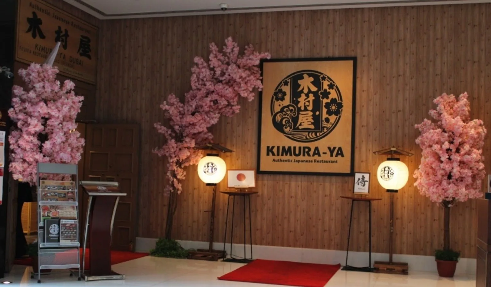 Kimura-ya entrance with cherry-blossom trees, lanterns and the brand emblem